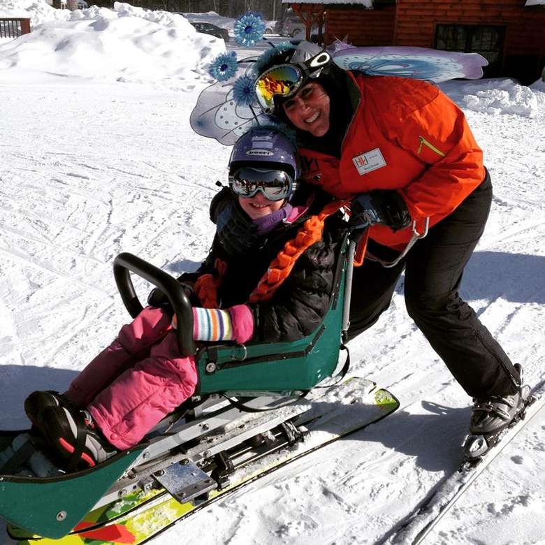 A young girl in a green sled-ski
