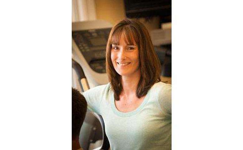 Woman in front of a treadmill smiling