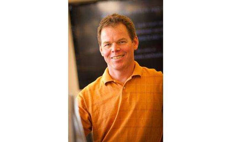 Man in front of a board smiling