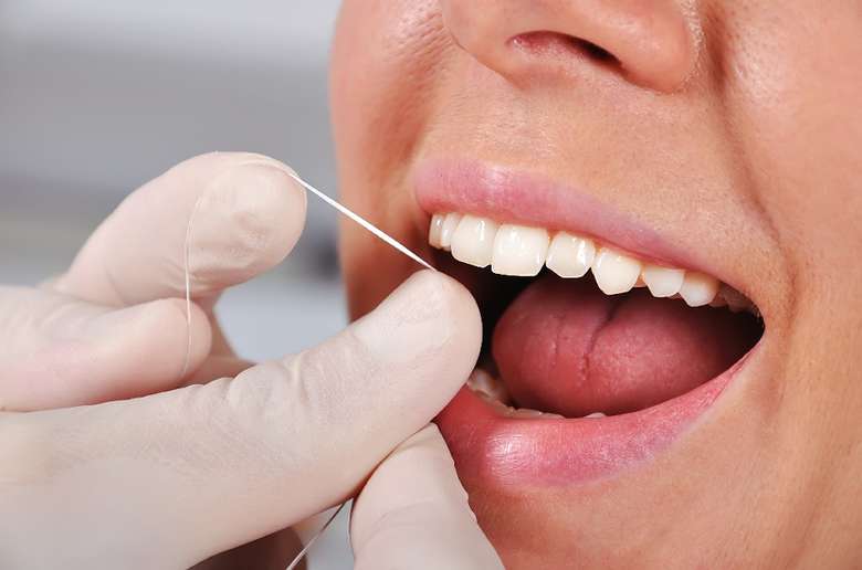 flossing a mouth at a dentist