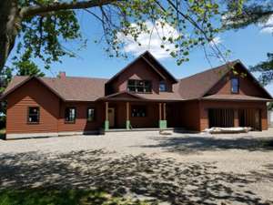 a large brown house and a spacious driveway lot