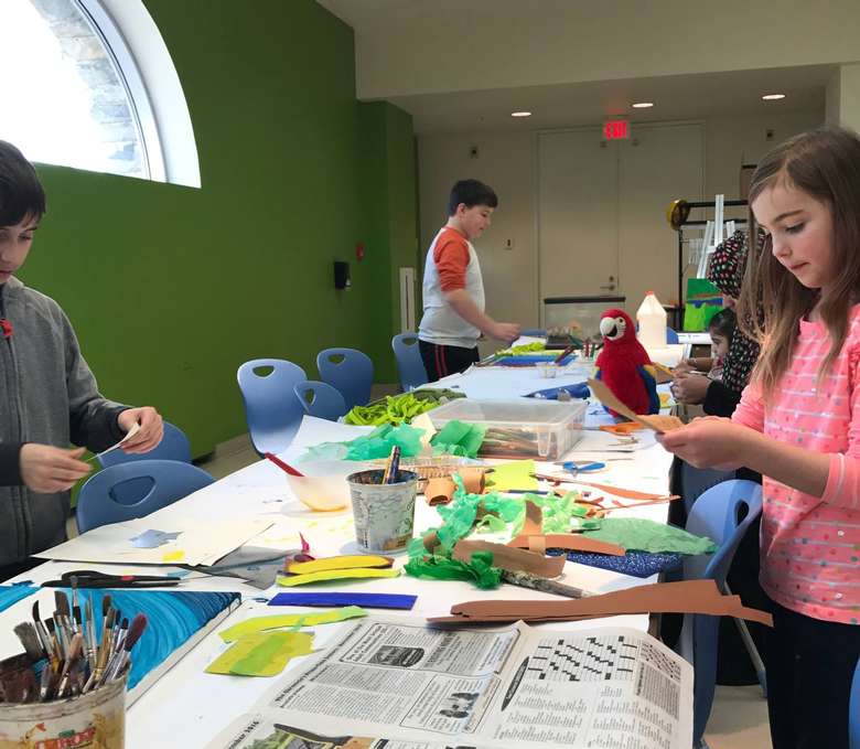 kids at a table working on a craft art project