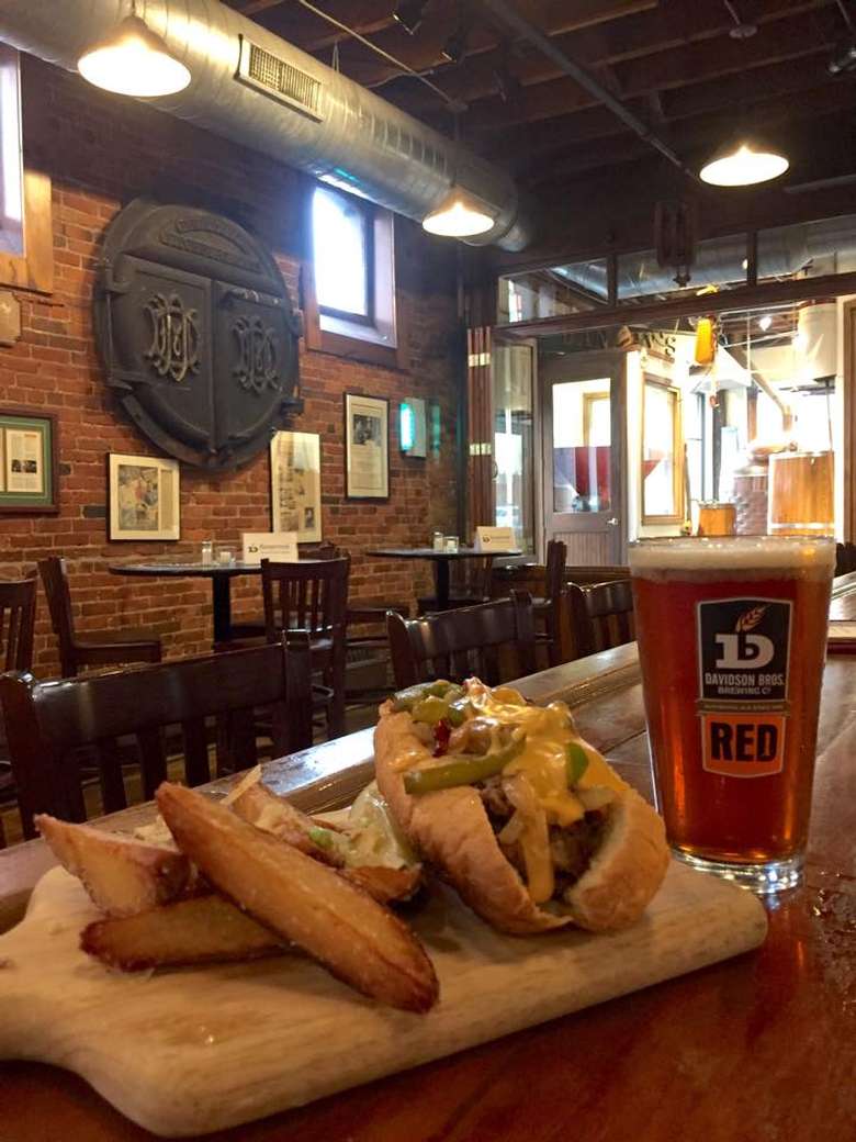 glass of beer and some food on a wooden platter