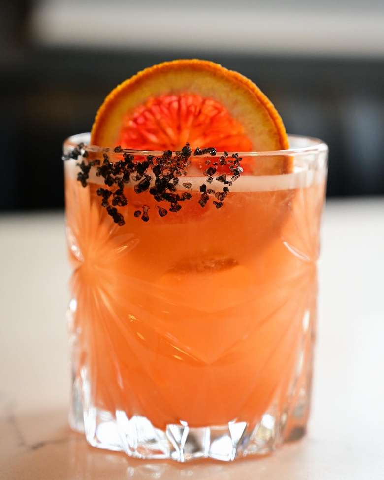 orange peach-ish cocktail with orange slice
