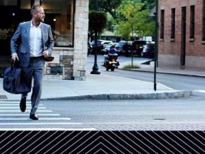 a sharply dressed man crossing the street