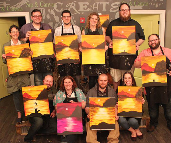 group of people holding up paintings