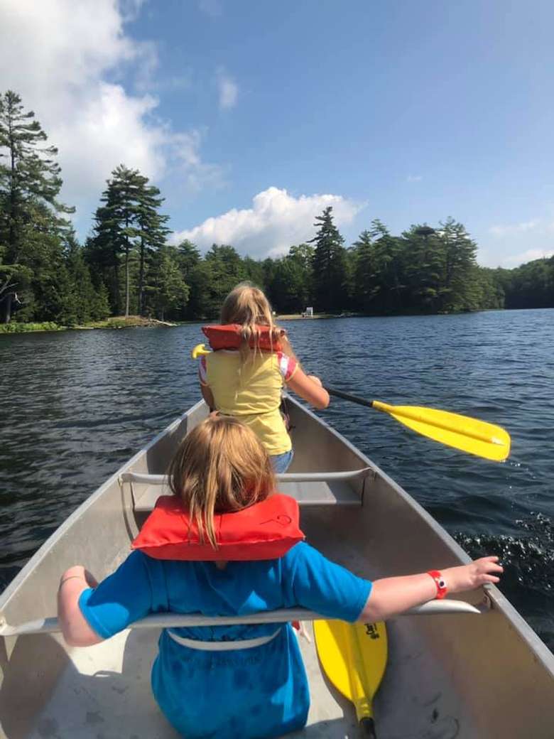 two kids in a canoe on a lake
