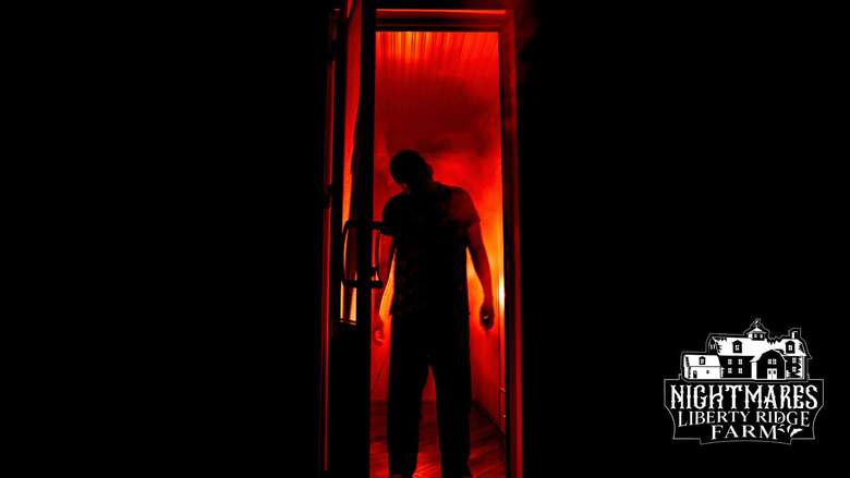 person standing in doorway in the darkness with red light behind them