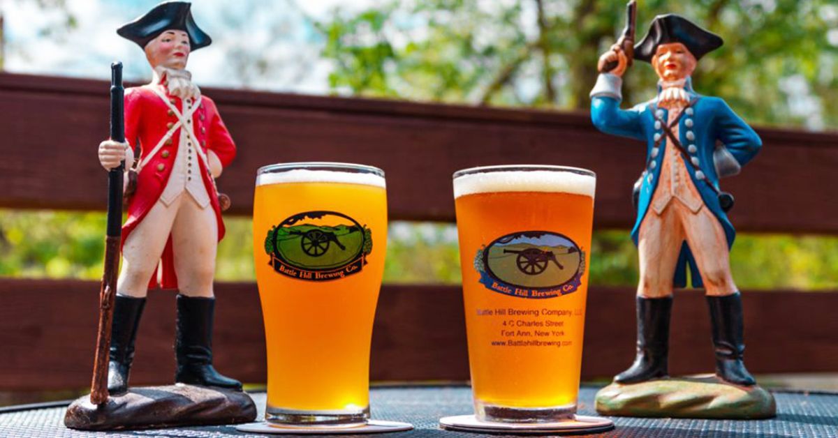 two glasses of beer with figurines beside them