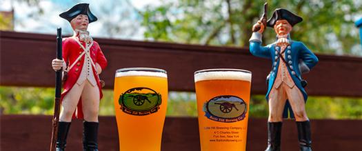 two revolutionary war figurines and two draft beers