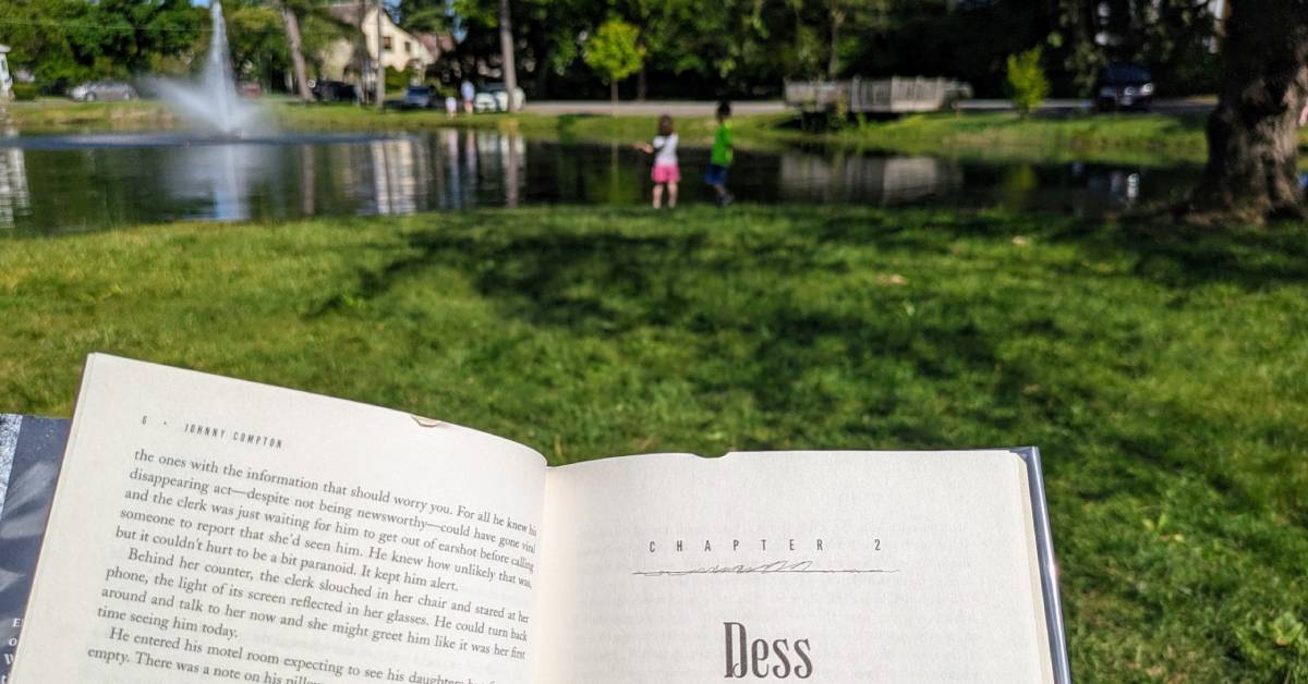 book held up in front of crandall pond