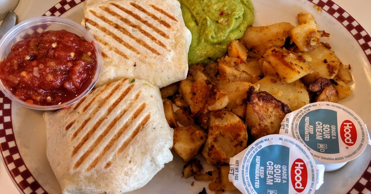breakfast burrito with home fries, salsa, guac, sour cream