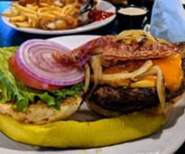 burger with bacon, cheese, lettuce, tomato, onion