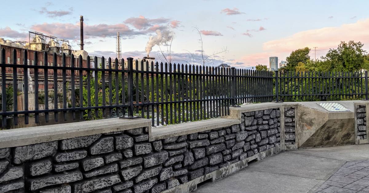 fence and wall area overlooking water and factory at cooper's cave
