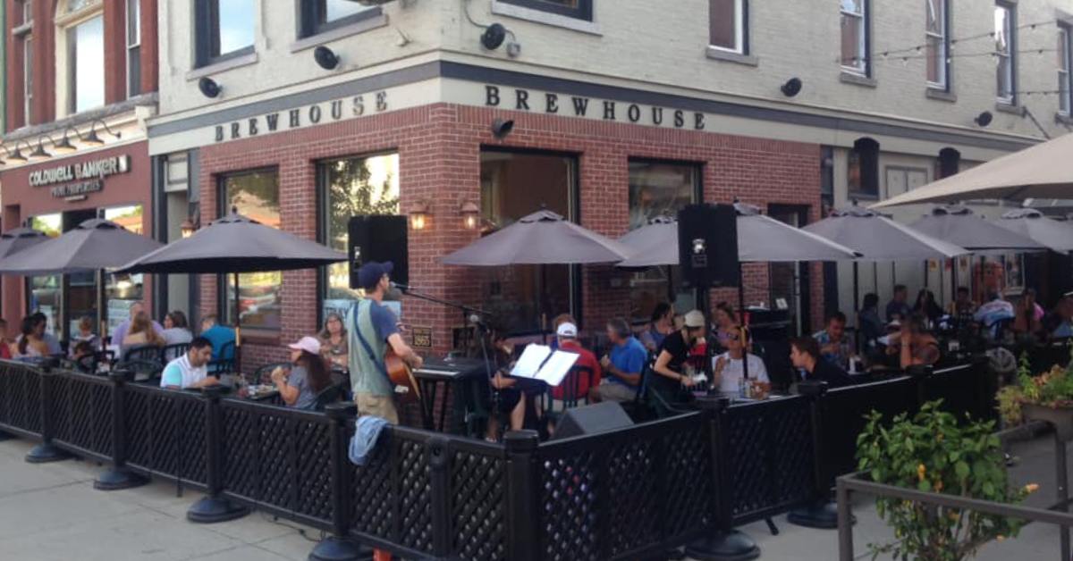 fenced in outdoor patio by a brewhouse