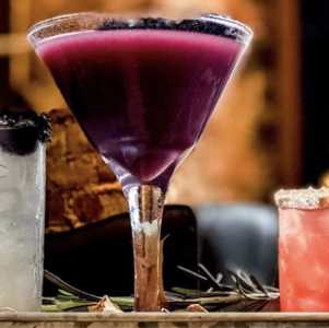 three colorful cocktails on a bar