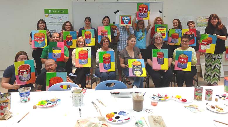 a group of paint and sip participants with their finished works