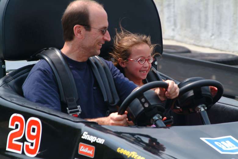 a father and daughter in a go-kart together