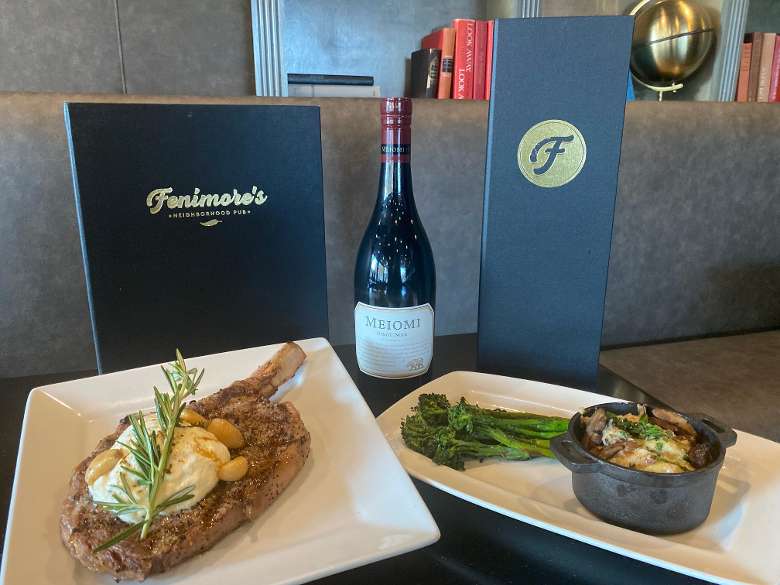 Dinner entree, menus and bottle of wine