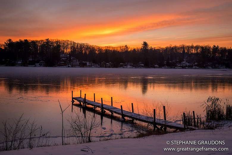 Sunset on Glen lake with orange Hues and a dock