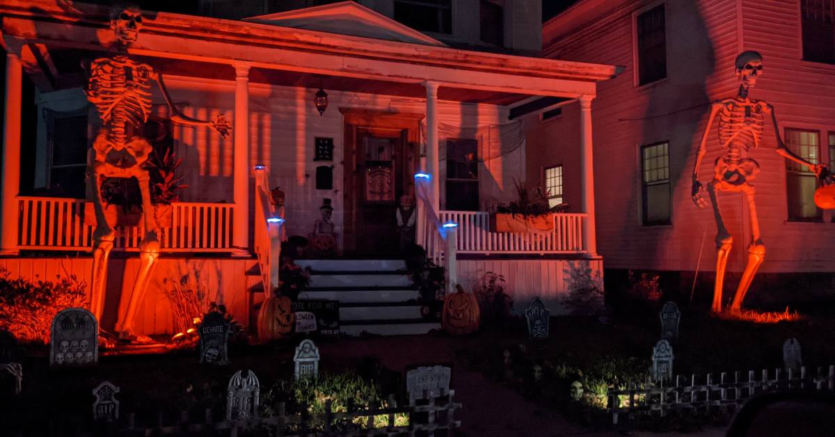 house decorated for halloween with giant skeletons