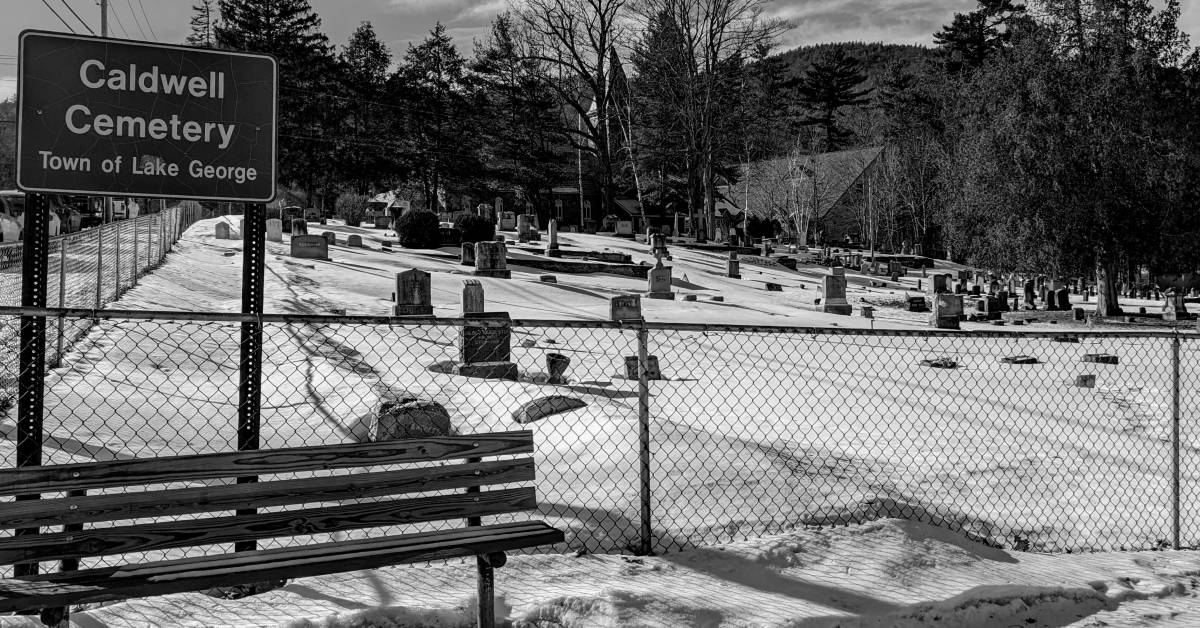 black and white image of caldwell cemetery with sign in lake george