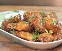 plated wings with cucumbers and dipping sauce in the background