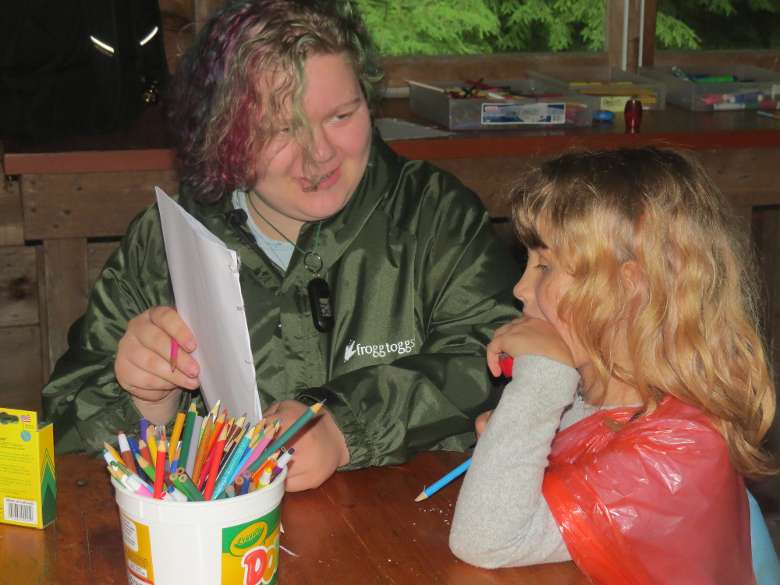 counselor instructs camper about art project