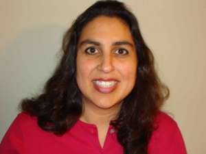 woman in red shirt smiling at camera