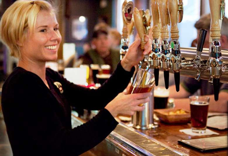 woman pouring beer from a tap