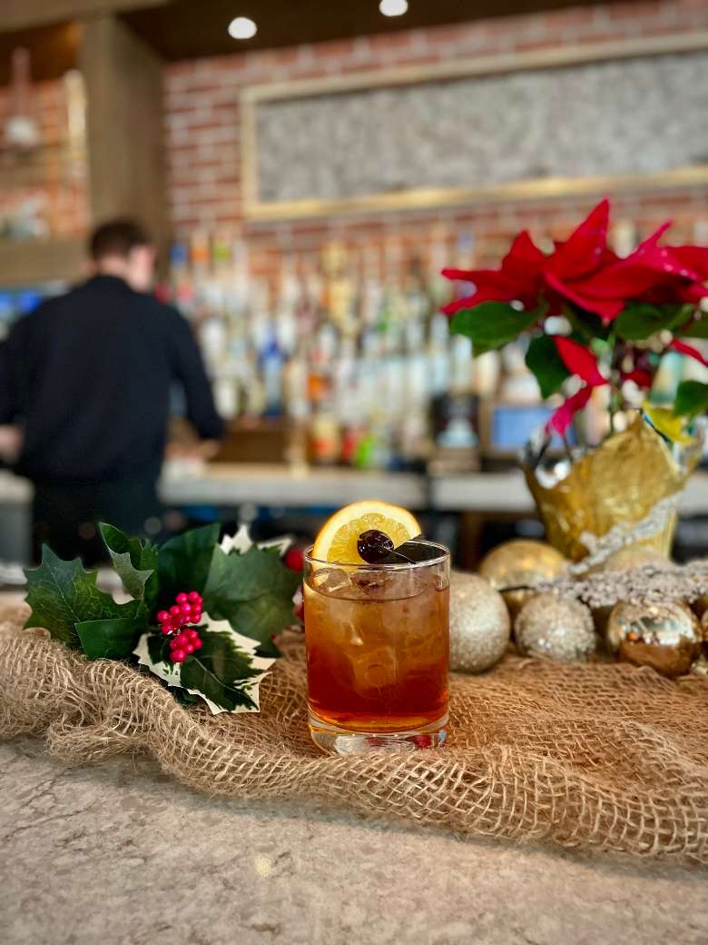 bourbon cocktail in front of a bar