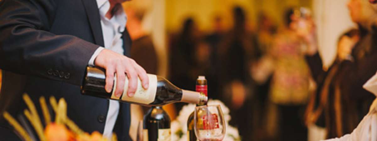 man pouring wine at a tasting
