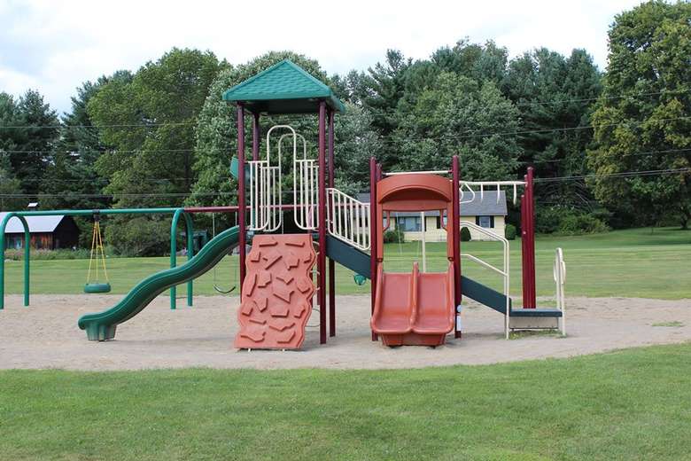 a playground at a park with slides and a climbing section