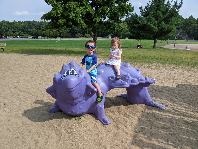 little kids on dragon structure in park