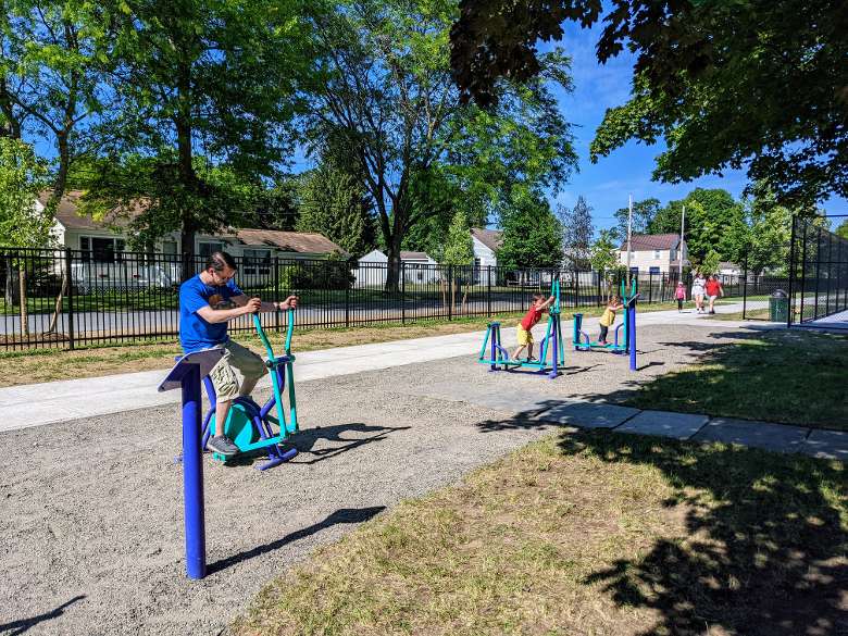 people on exercise equipment in park