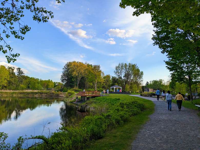 people walking around the path around the pond