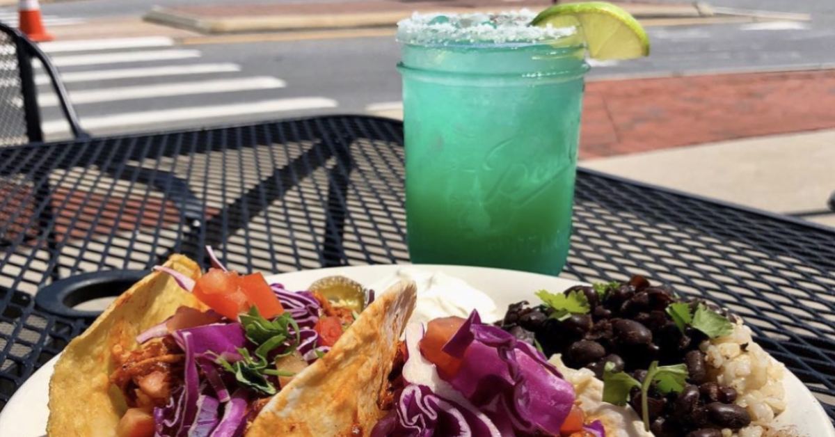 margarita on a table with plate of food