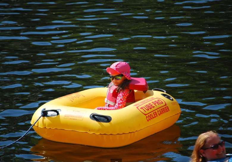 a young girl sitting in a yellow raft tube