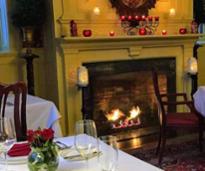 romantic restaurant set for valentine's day with fire in fireplace